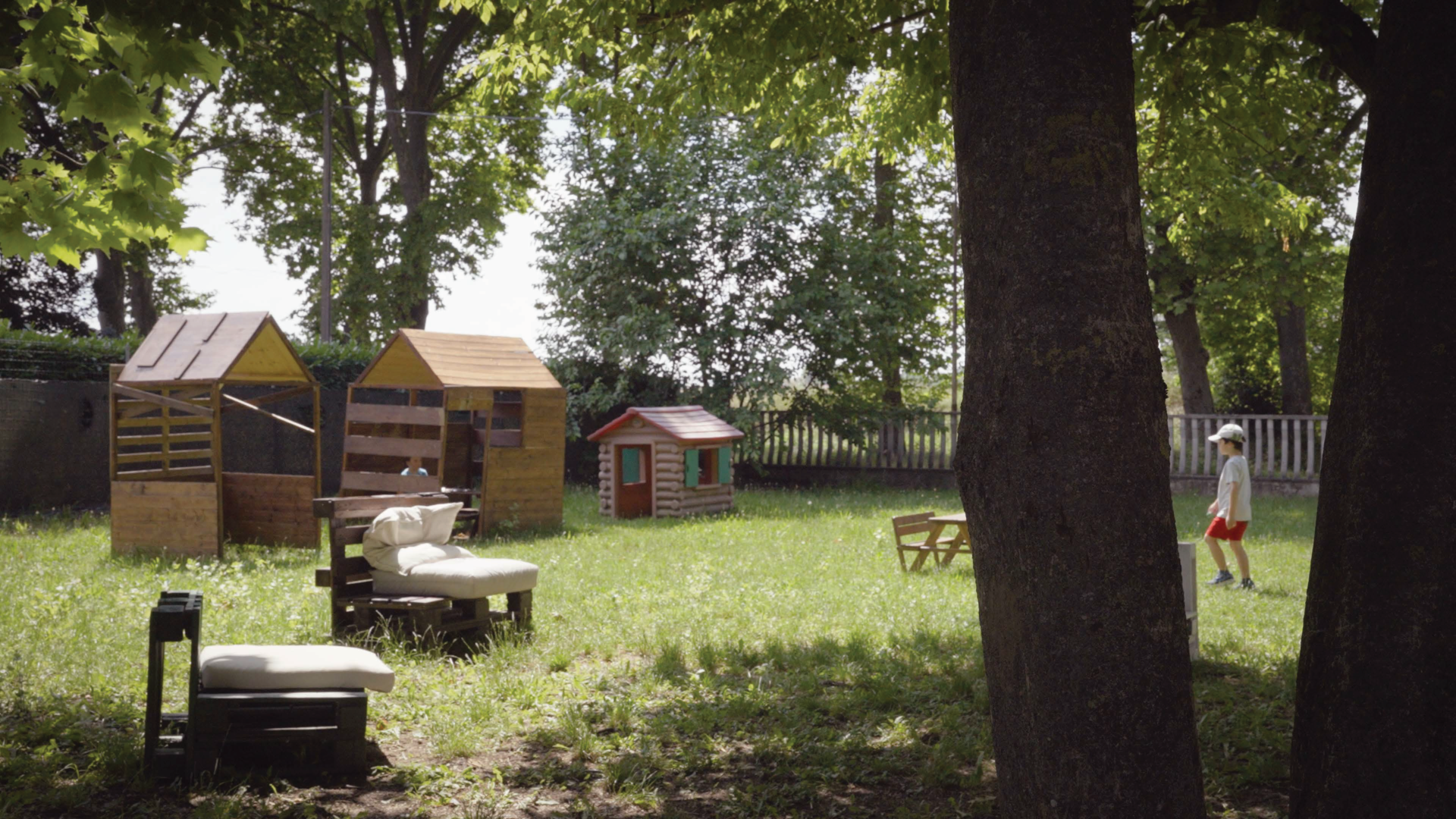 Una porzione del parco che circonda la scuola montessoriana, con scivoli e casette di legno.