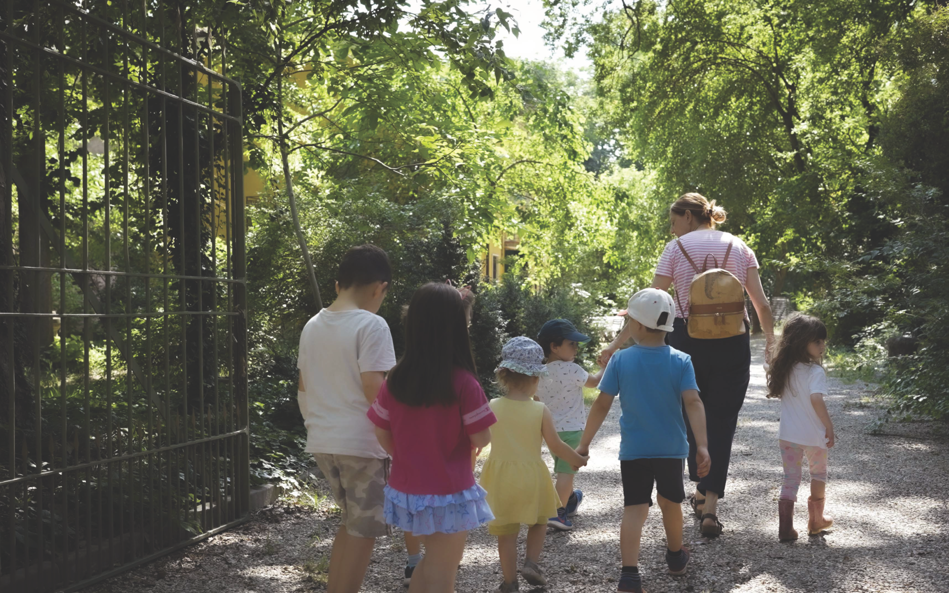 Educatrice certificata dall’Ordine nazionale Montessori, insieme a un gruppo di bambini, in gita all’interno di un parco.