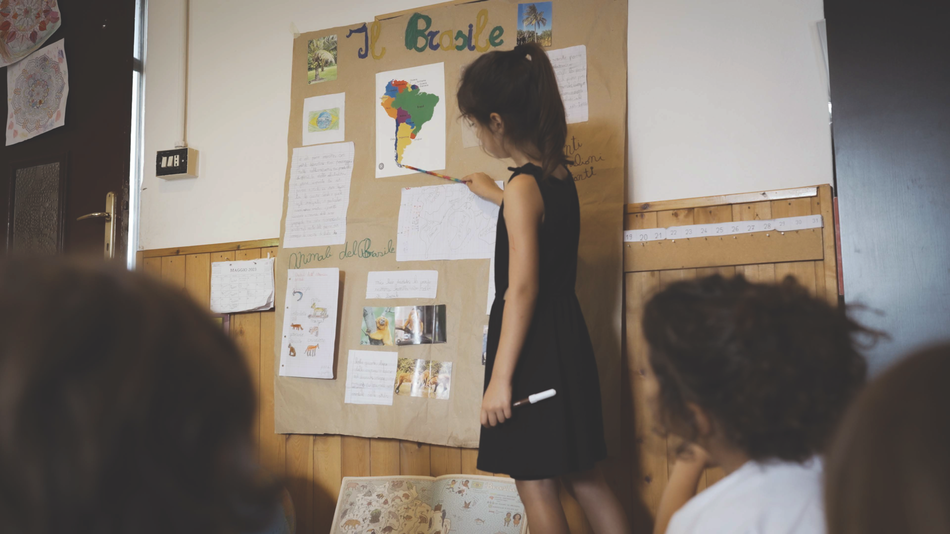 All’interno di un’aula della classe primaria, una ragazzina racconta ai compagni il suo progetto sul Brasile.